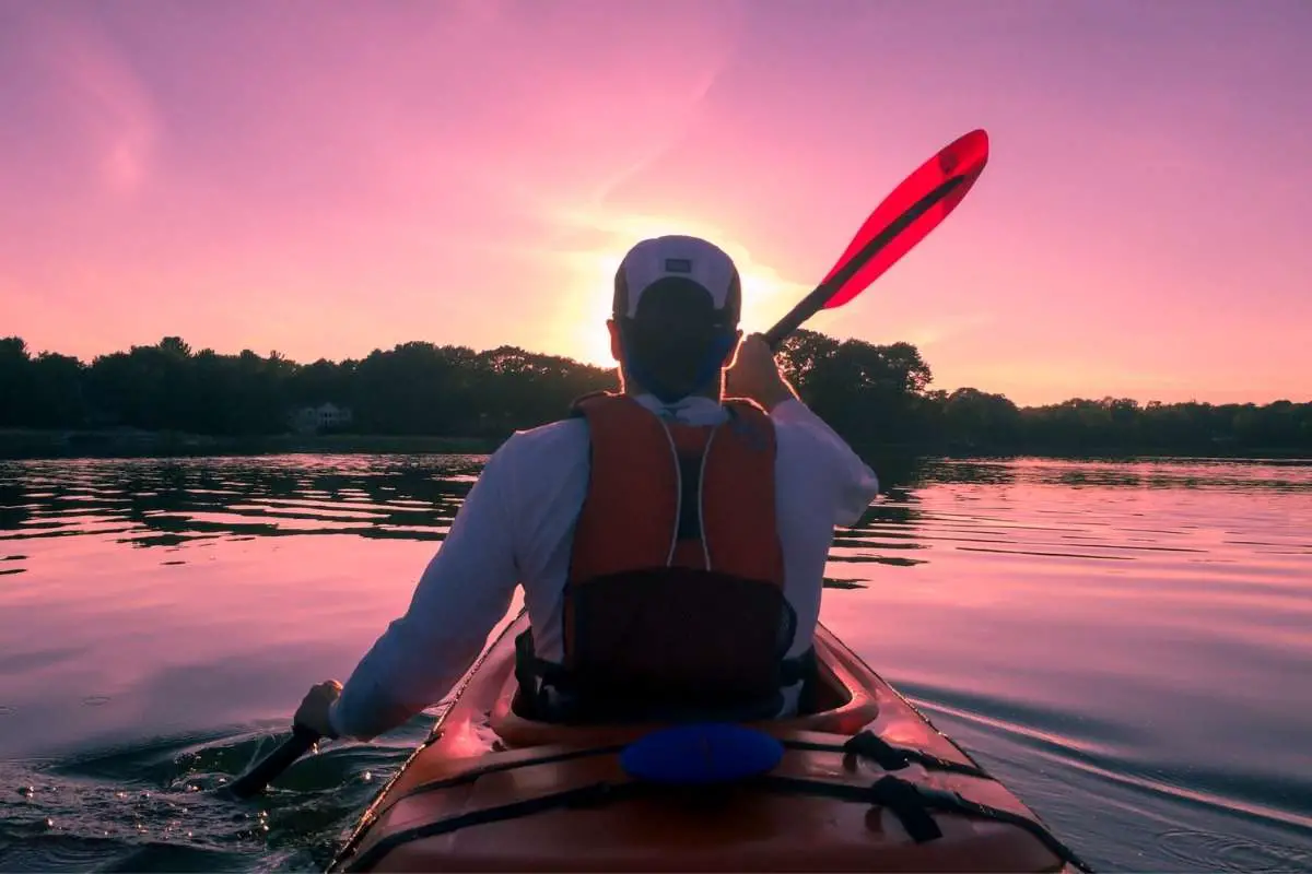 Kayaking on a calm lake at sunset.