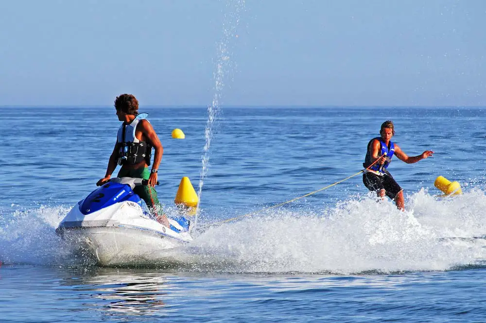 Man on a jet ski towing a person waterskiing.