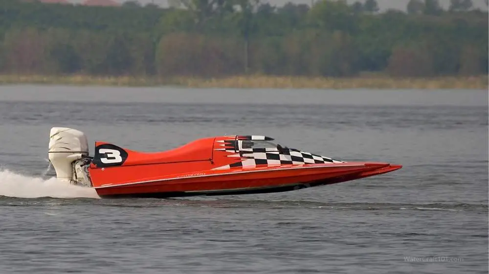 A red go-fast boat speeds across the water