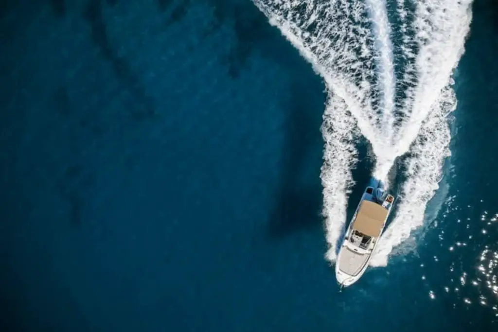 blue speed boat driving on sea waves