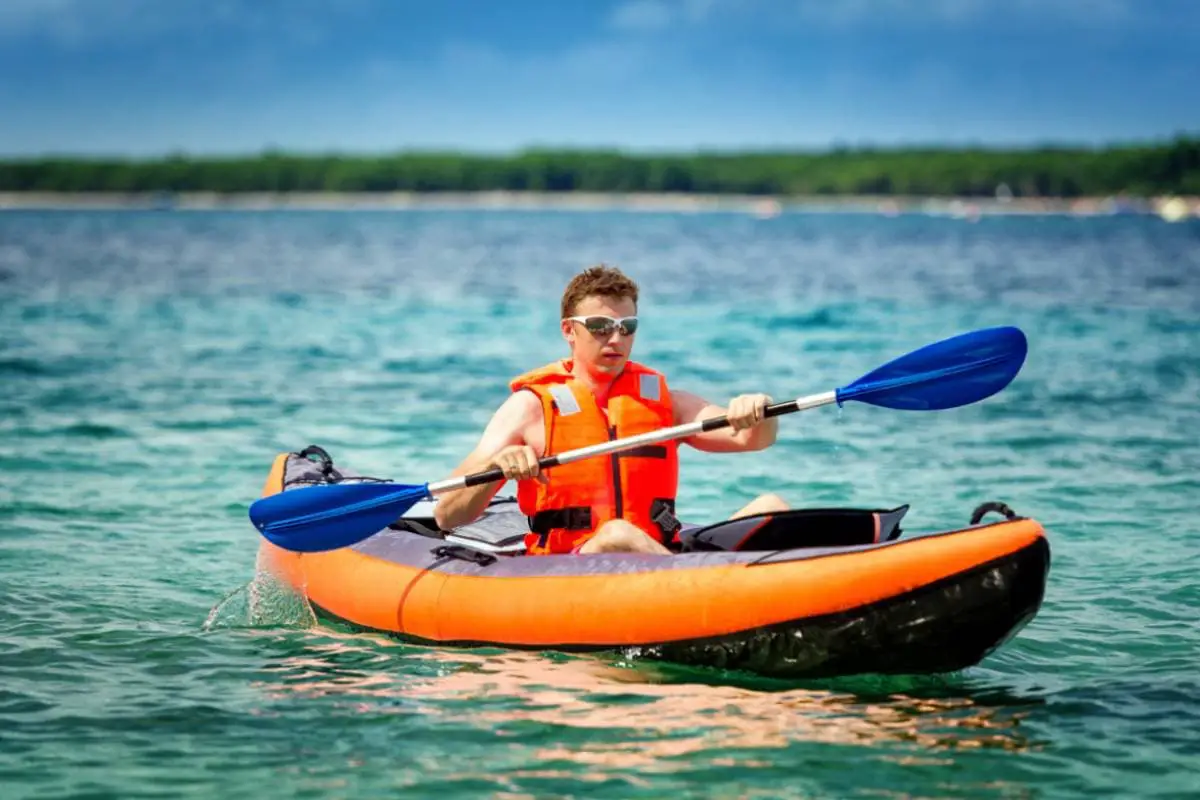 young man paddle a kayak on the sea